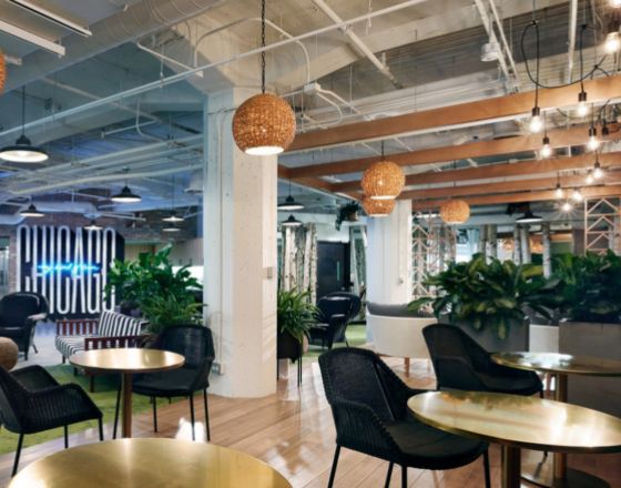 open seating area with wooden floor, small tables, and planter dividers